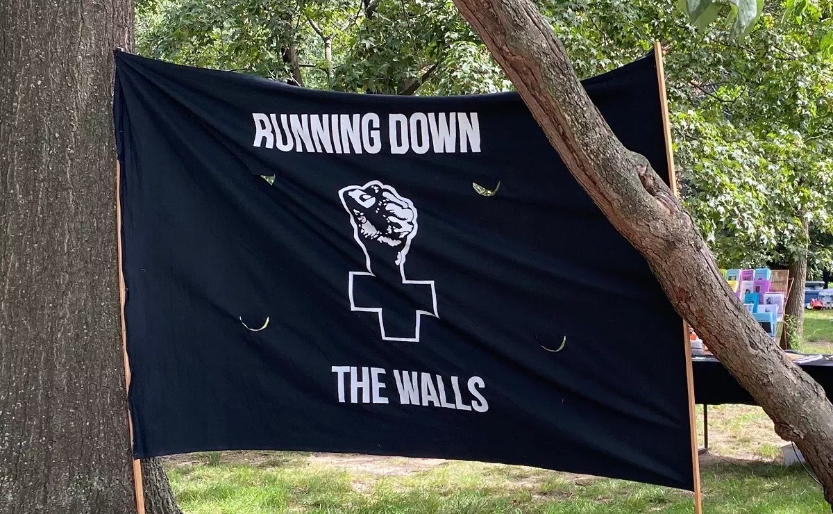 Black Flag with the Anarchist Black Cross logo and the text "Running Down the Walls"